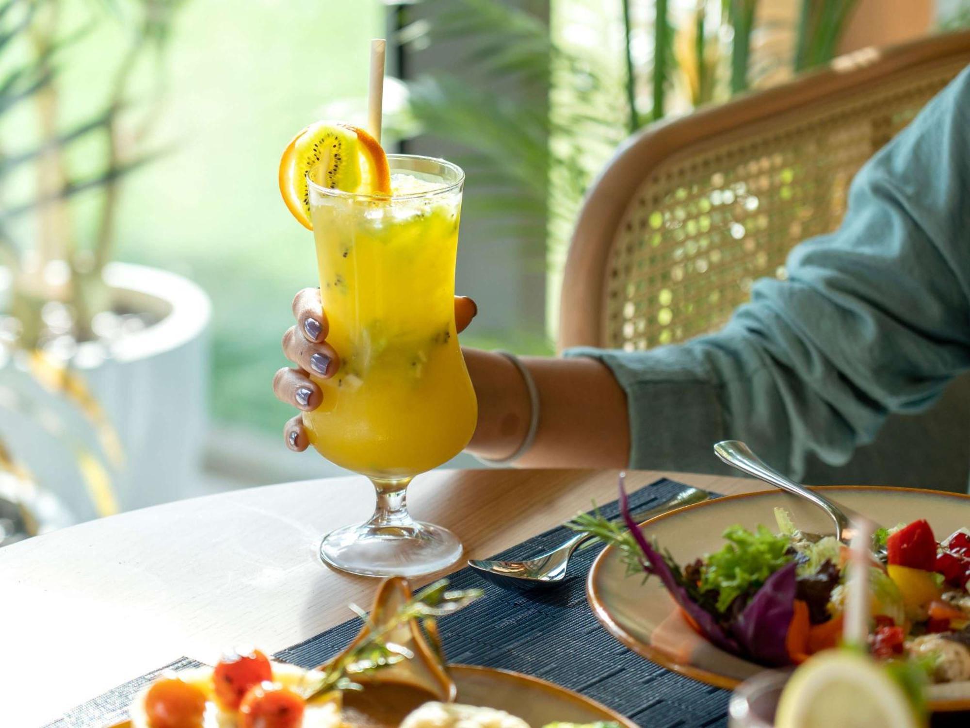 Swissotel Living Джидда Екстер'єр фото A woman holding a glass of juice